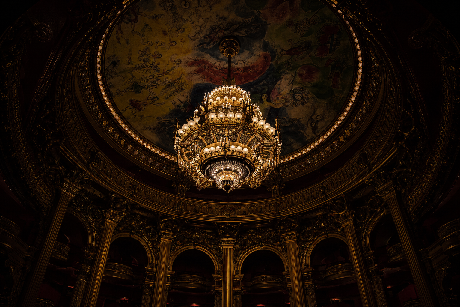 Lustre monumental suspendu sous la coupole peinte du Palais Garnier à Paris.