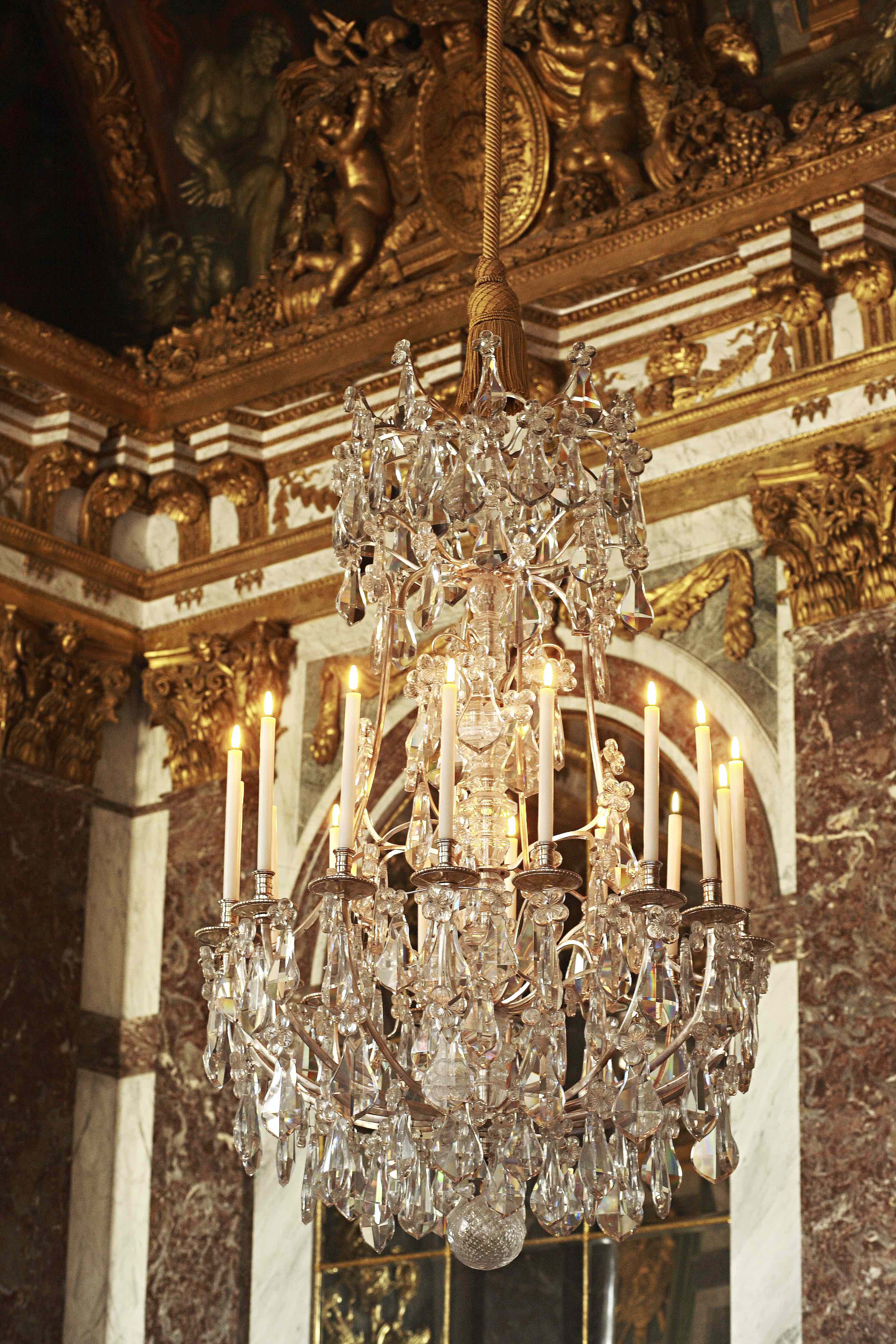 Crystal chandelier in a ornate room with gold accents